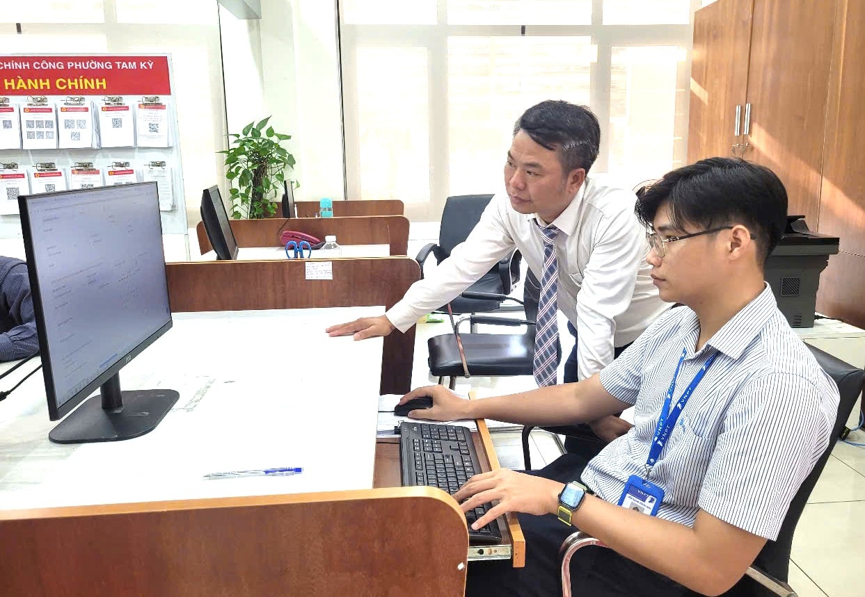 Cán bộ kỹ thuật VNPT hỗ trợ công chức phường Tam Kỳ trong thời gian đầu vận hành thử nghiệm mô hình chính quyền 2 cấp. Ảnh: VINH ANH