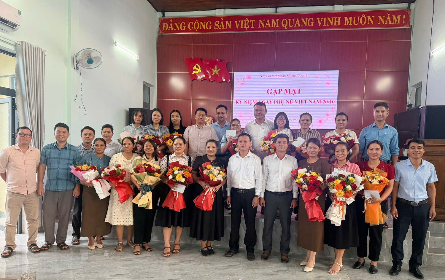 Ảnh: lãnh đạo xã tặng hoa chức mừng chị em phụ nữ